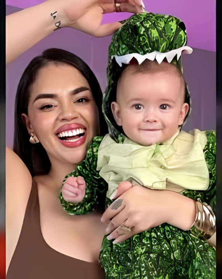 Mãe sorridente segurando seu bebê pequeno com acessórios verdes